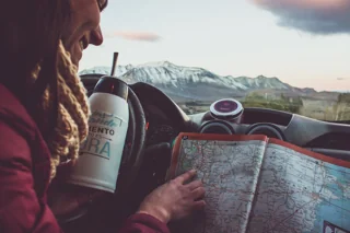 Ruta cordillerana y mapa turístico junto a un mate, evocando los sabores andinos